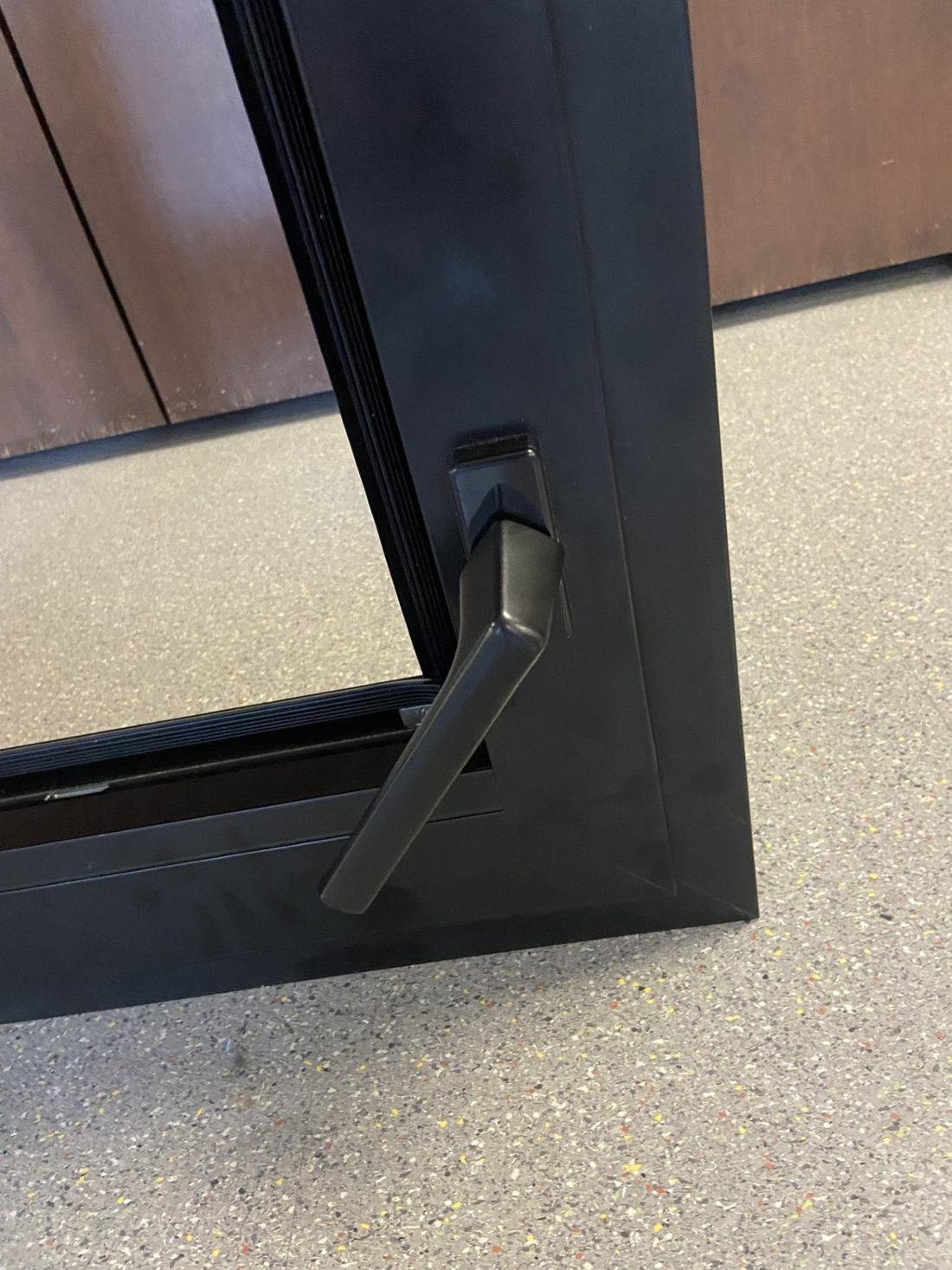 Close-up of a black window handle and frame