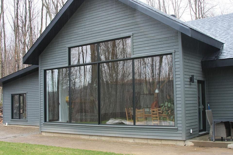Grey-sided house with a large black-framed window wall